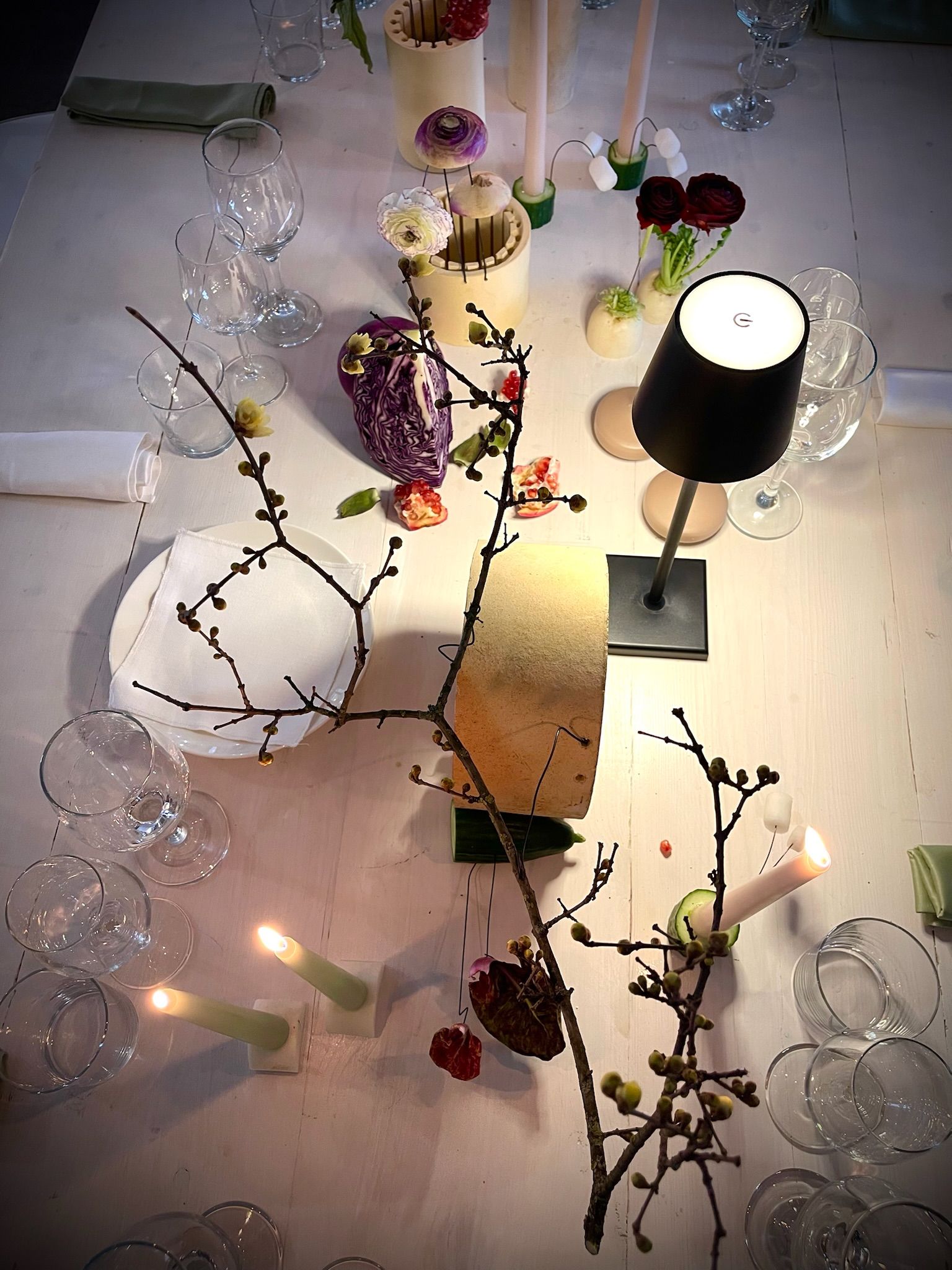 Tavola d'evento con candele, lumi e composizioni botaniche