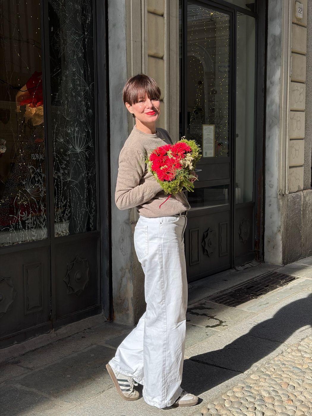 Sposa con bouquet rosso per le vie della città