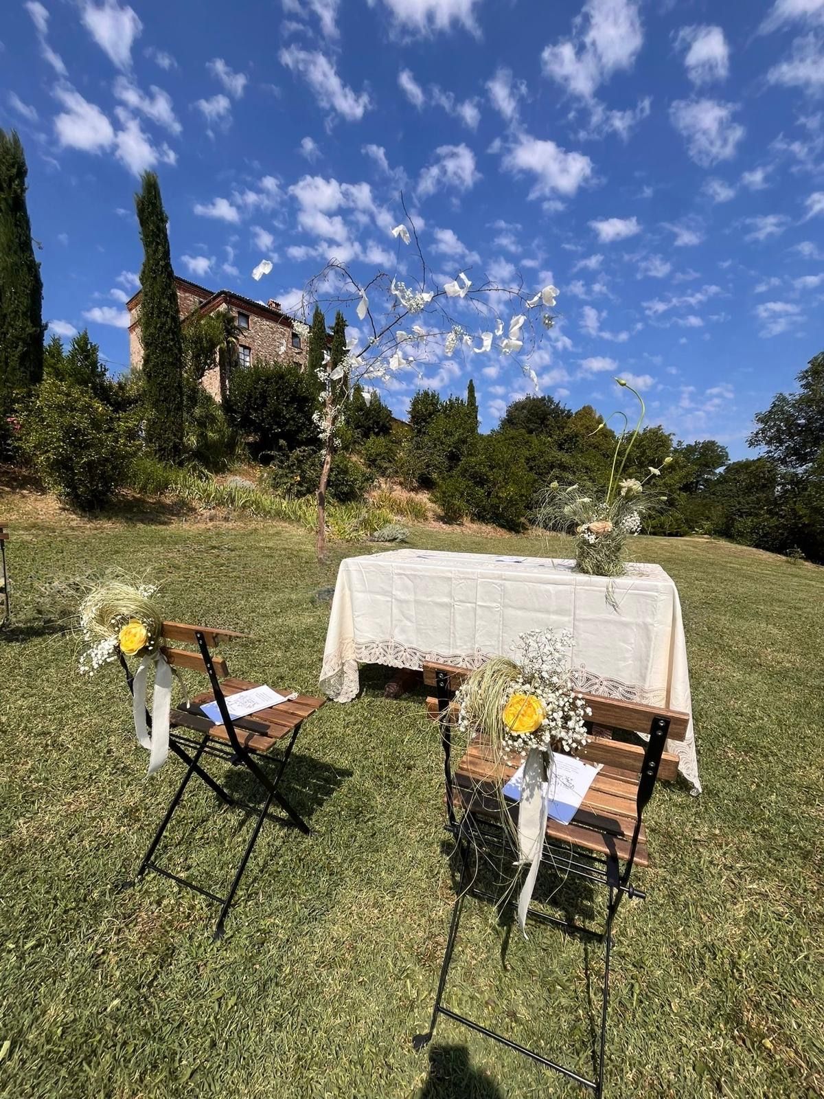 Cerimonia civile all'aperto: tavolo del rito con tovaglia bianca e sedie sul prato
